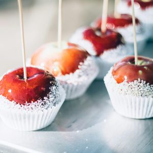 Close-up of red caramel apples with sugar coating on sticks. Perfect for sweets and confectionery themes.