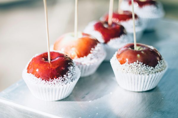 Close-up of red caramel apples with sugar coating on sticks. Perfect for sweets and confectionery themes.